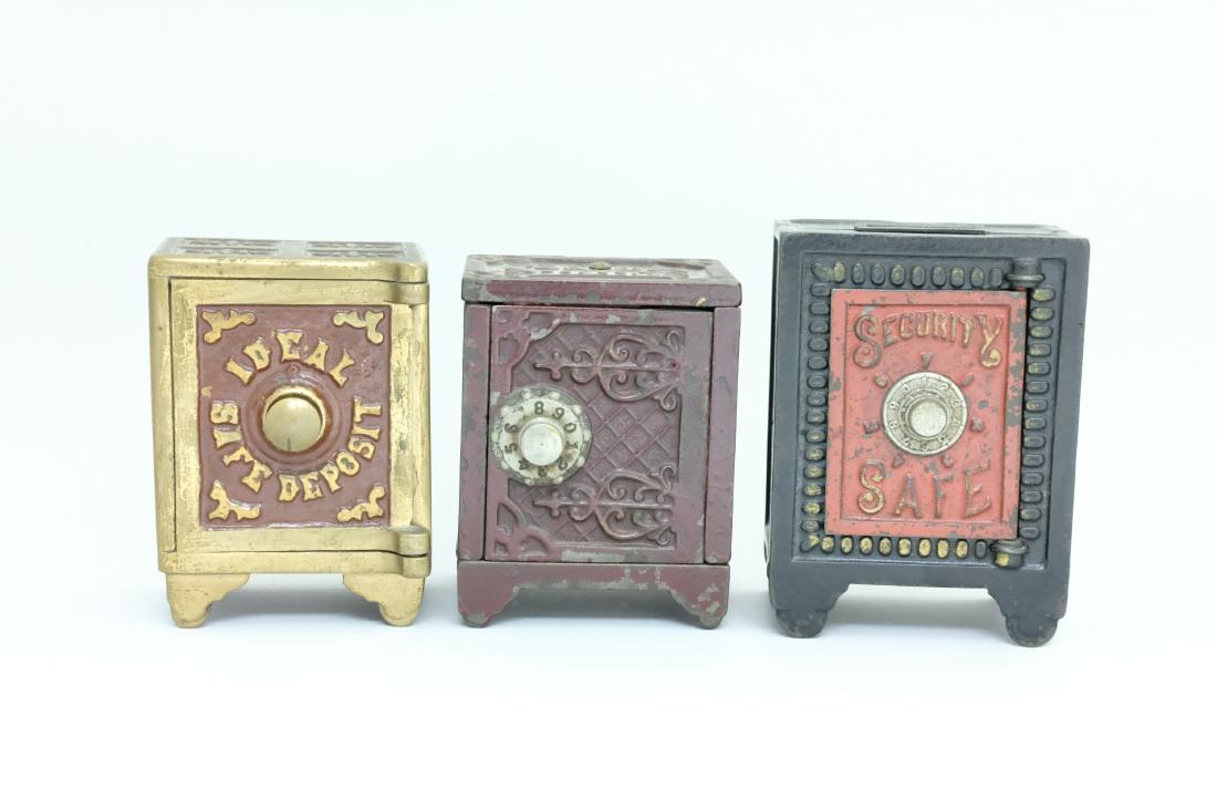 Three Safes: American - 1895/1910 - 3.875" - 4.5" T The Ideal Safe Deposit is painted brass and hails from the famed Larry Egelhoff Collection. Larry Egelhoff Collection Material: Cast Iron / Brass