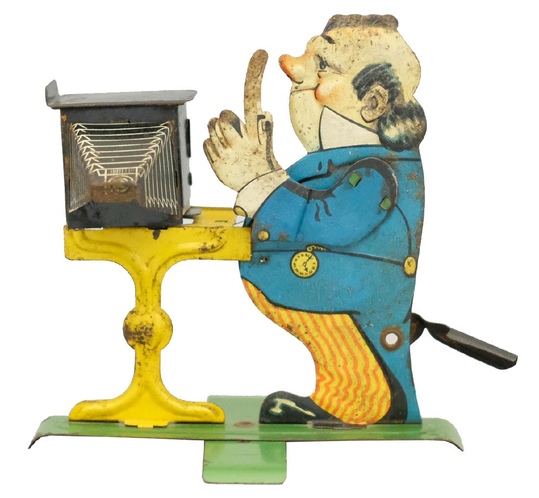 The Photographer: George Levy (GELY) Germany - Circa 1920 - 5" T This is a hand operated toy that works well. It retains its original photograph. Material: Tin