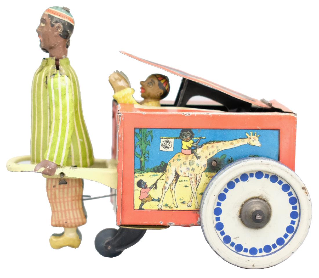 Mandarin Pulling Cart: Greppert & Kelch (G&K) German - Circa 1910 - 6.25" L As the toy moves along a boy peaks out of the cart. Works well. Material: Tin