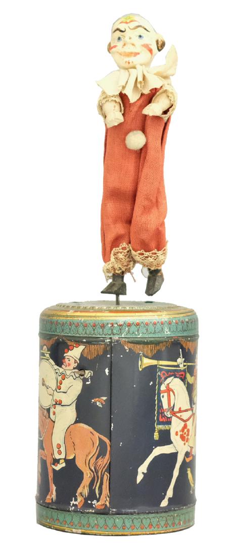 Clown on Musical Drum: German - Circa 1920 - 10.25" T This is a hand operated musical toy. The clown goes around and the music plays. It works quite well. Material: Composition, wood, fabric and tin