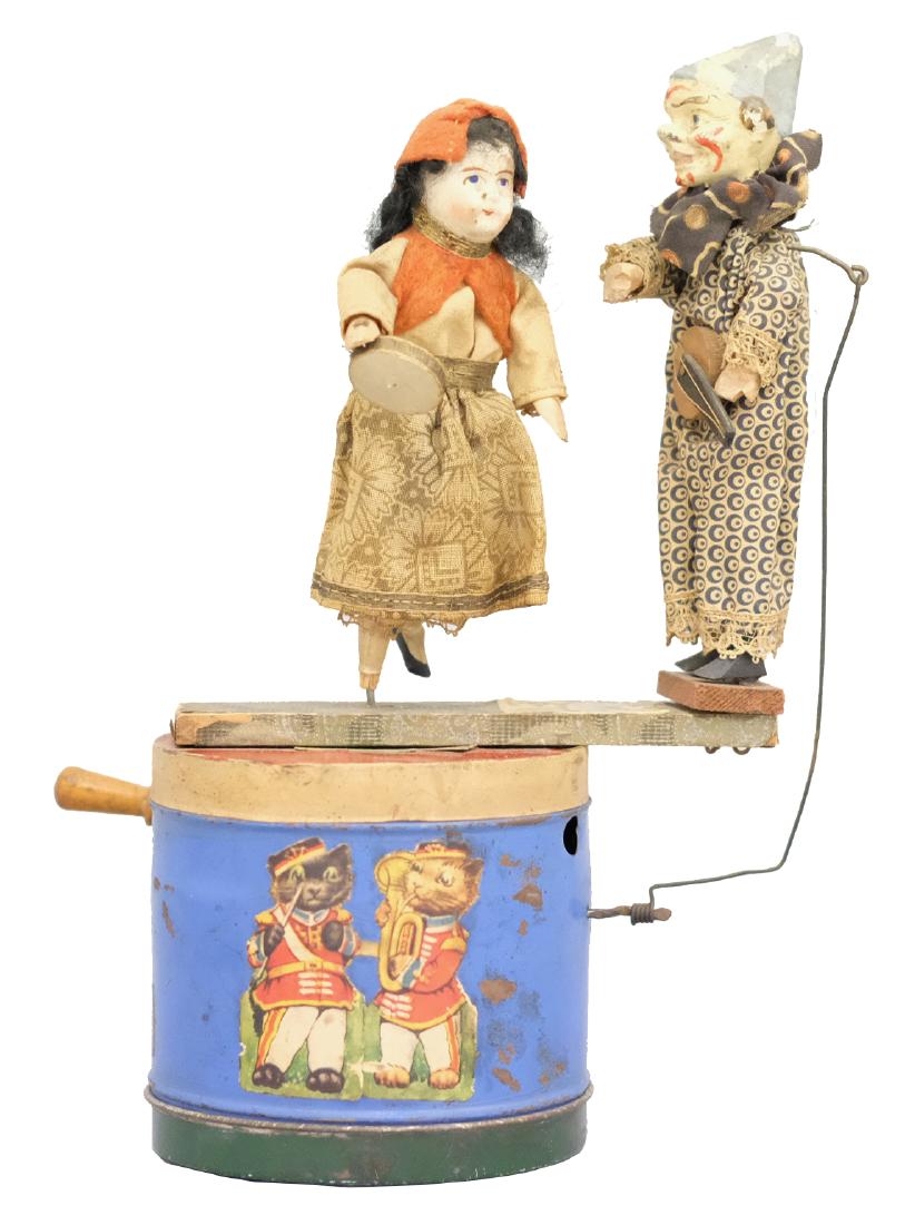 Clown and Gypsy on Musical Drum: Continental - Circa 1920's - 10" T This is a hand operated musical toy. The gypsy dances around and the clown plays his mandolin. Material: Composition, wood, fabric and tin
