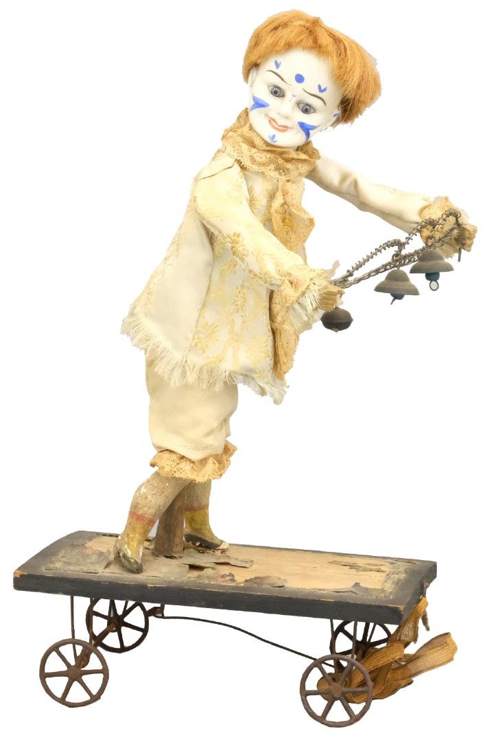 Clown with Bells Pull Toy: German - Circa 1910 - 13" T As the toy is pulled he moves side to side ringing his chimes. Material: Wood, fabric tin and bisque