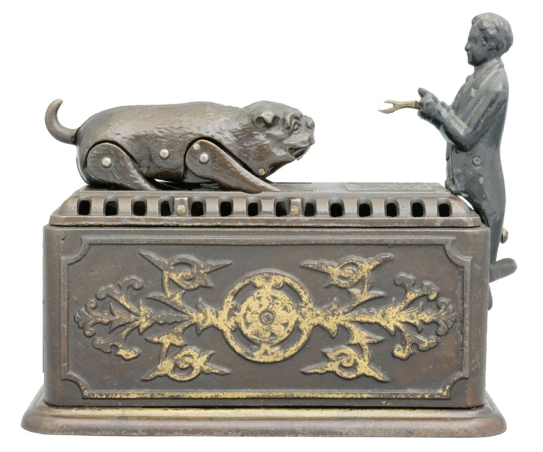 Snapping Bulldog: Ives, Blakeslee & Company Bridgeport, CT - Circa 1878 This is a clockwork toy bank, which must be wound-up in order to operate. Once wound, place a coin in the man’s hands and press the lever beneat
