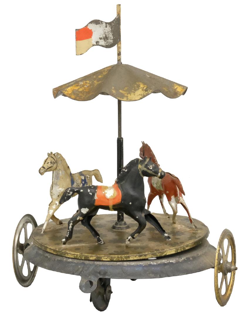 Horses Go Round Pull Toy: Probably French - Circa 1910 - 7.5" T As this inventive toy is pulled, the horses turn around as does the canopy. Material: Tin