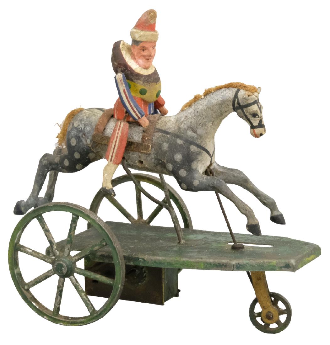 Punch on Horseback: Buchner German - Circa 1880's - 5.125" T This is an early and fragile hand painted toy that remains in Excellent and Bright condition. As he rolls along, the horse goes up and down. Material: Tin and 