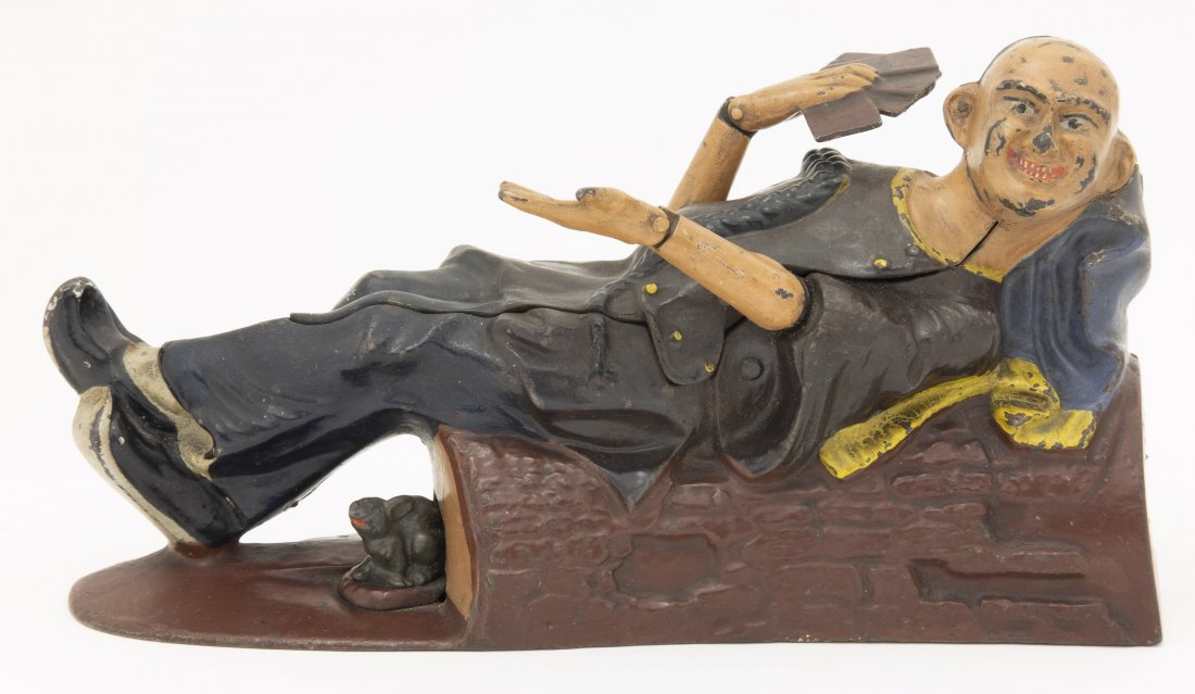Reclining Chinaman Iron Mechanical Bank: J. & E. Stevens. Cromwell, CT - 1882. This is a graphic depiction of a Chinaman reclining in an opium den while playing cards. He reveals four aces. The moral of the lesson "Never Trust a Chinaman". C