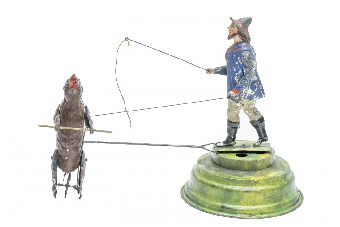 Gunthermann Bear with Trainer: German, circa 1905, 12" L x 9" T Thi is the large scaled and rare version of this German painted toy. It works well, as he goes around plinkety-pink music is played.