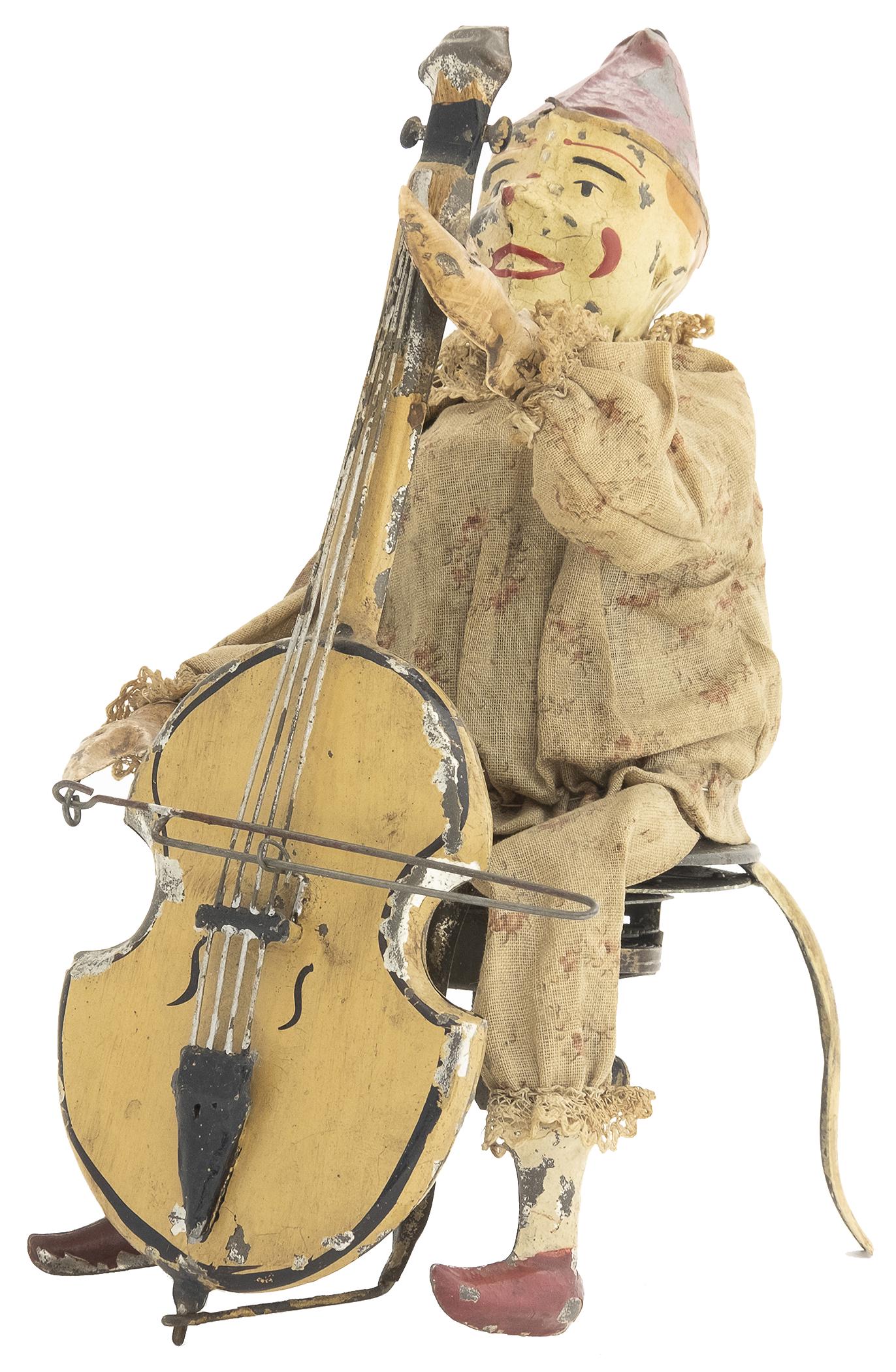 Gunthermann Clown with Cello: German, Circa 1915, 8.25" T This is an impressive toy that incorporates both tin and fabric. He plays plinkety- plink music.