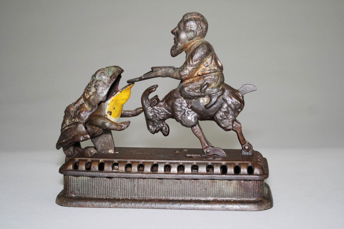 Goat, Frog and Old Man Mechanical Bank: Made by Mechanical Novelty Works New Britain, Connecticut – Circa 1885 Also known as the "Initiating Bank – 2nd Degree". It functions by placing a coin in the man's tray and then either pressing t