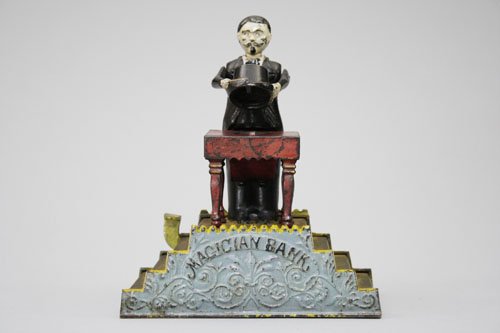 Magician Bank: Made by J. & E. Stevens Cromwell, Connecticut – Circa 1901 “Now you see it, now you don’t”. So goes the action of the ever-popular Magician Bank. It is one of the most beautifully designed ban