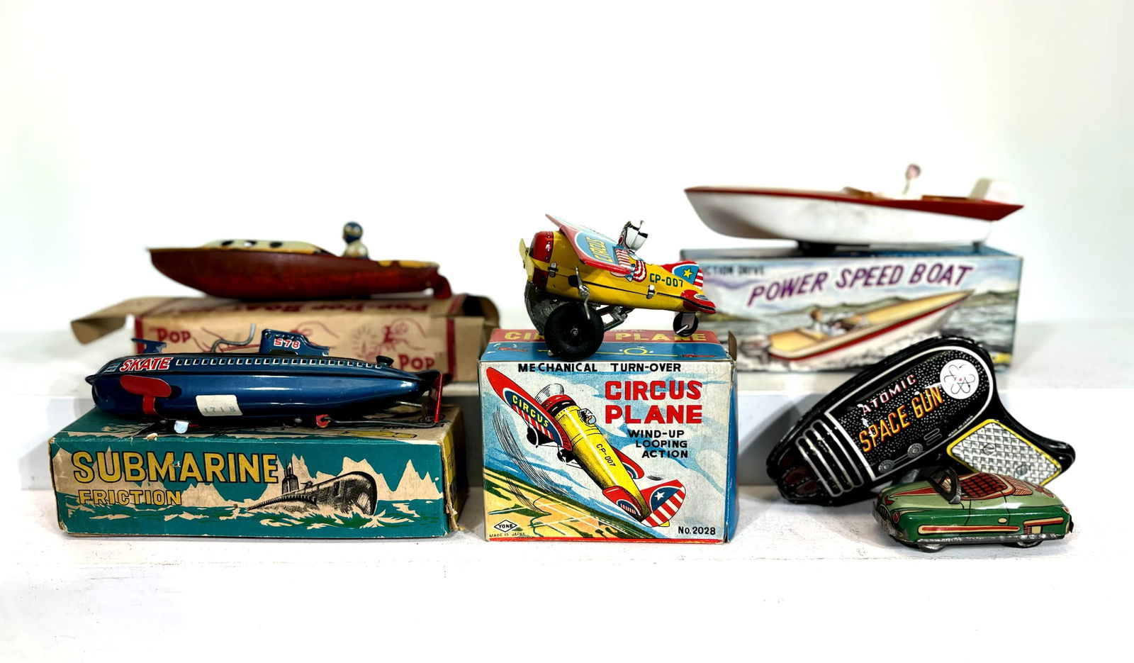 Six Tinplate Toys: Japanese - 1950/60's - Largest is 7" Long. Lot includes three boats, one plane, one auto and a space gun.