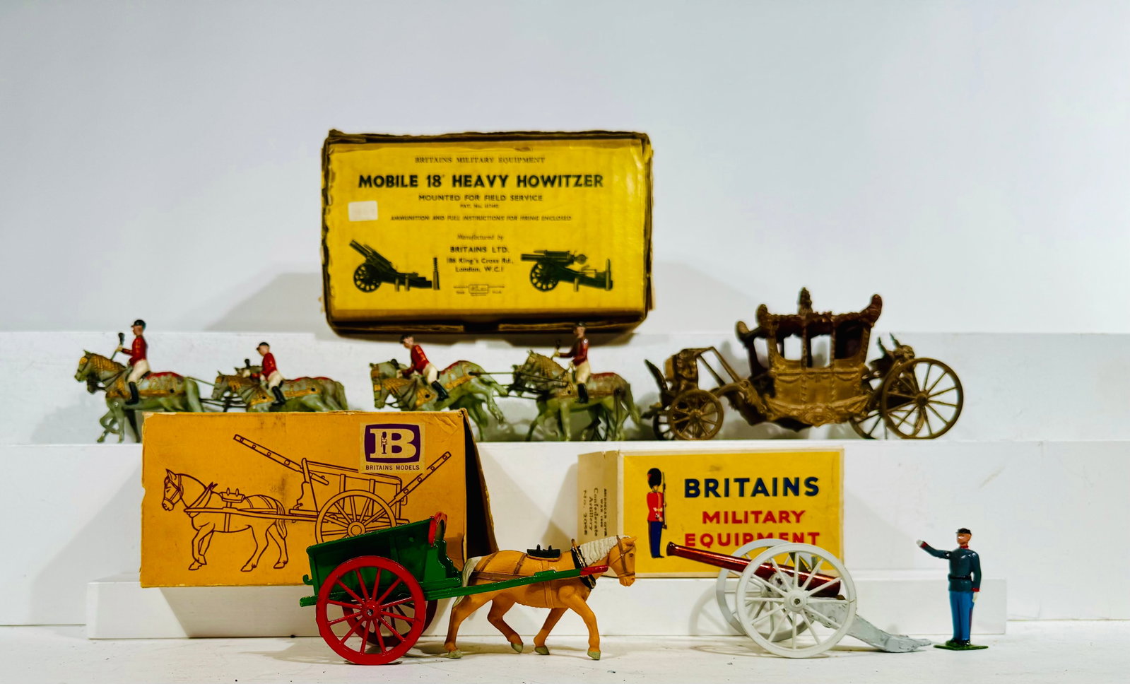 Four Britains Toys: English - 1950/60's - Longest 11" Long. Included are a coronation coach, howitzer cannon, civil war cannon and a farm wagon.
