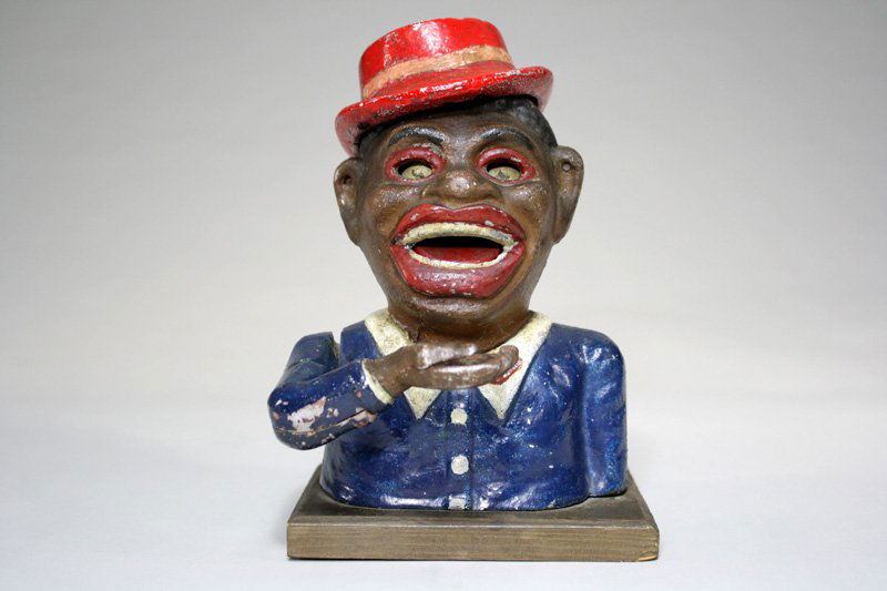 Jolly N. with Red Hat Mechanical Bank: Austrian – Circa 1930 This is a scarce and desirable coin-swallowing bank. Material: Aluminum