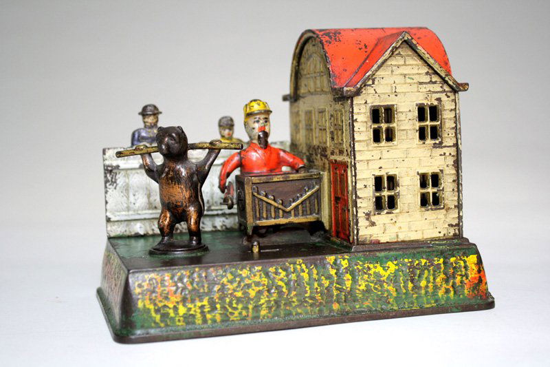 Organ Grinder and Performing Bear Mechanical Bank: Made by Kyser & Rex Co. Philadelphia, Pennsylvania – Circa 1882 This is one of only two mechanical banks with windup mechanisms. This bank is pretty, desirable and charming. Material: Cast Iron