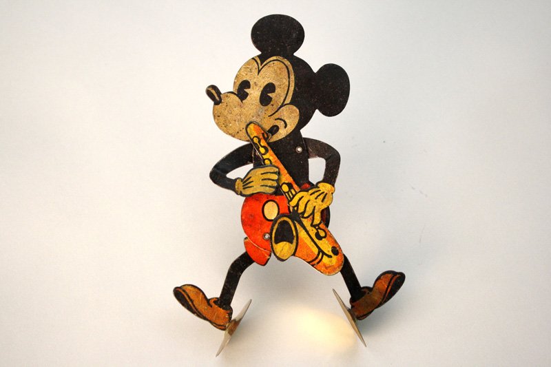 Mickey Mouse Clapping Toy Wind Up Toy: Germany – Circa 1928 Mickey Mouse playing saxophone and clapping. The toy is 6” tall. Material: Tin