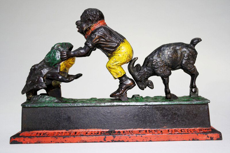 Initiating Bank 1st Degree Mechanical Bank: Made by the Mechanical Novelty Works New Britain, Connecticut – Circa 1895 Place a coin in the boy’s hands. Depress the lever, the goat butts the boy forward and the coin is thrown into the frog.