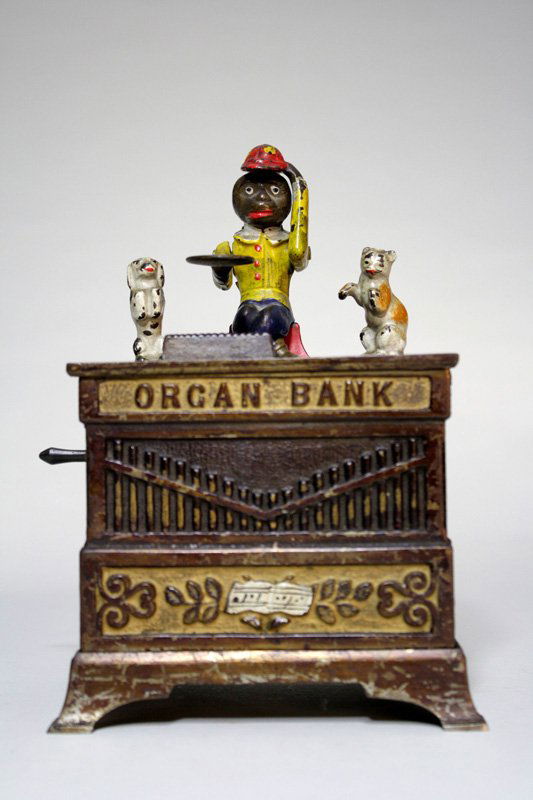 Organ Bank, Cat and Dog Mechanical Bank: Made by Kyser & Rex Company Philadelphia, Pennsylvania – Circa 1882 The monkey doffs his hat in thanks for the penny you have given him. The dog and cat rotate and the bells chime when the crank is