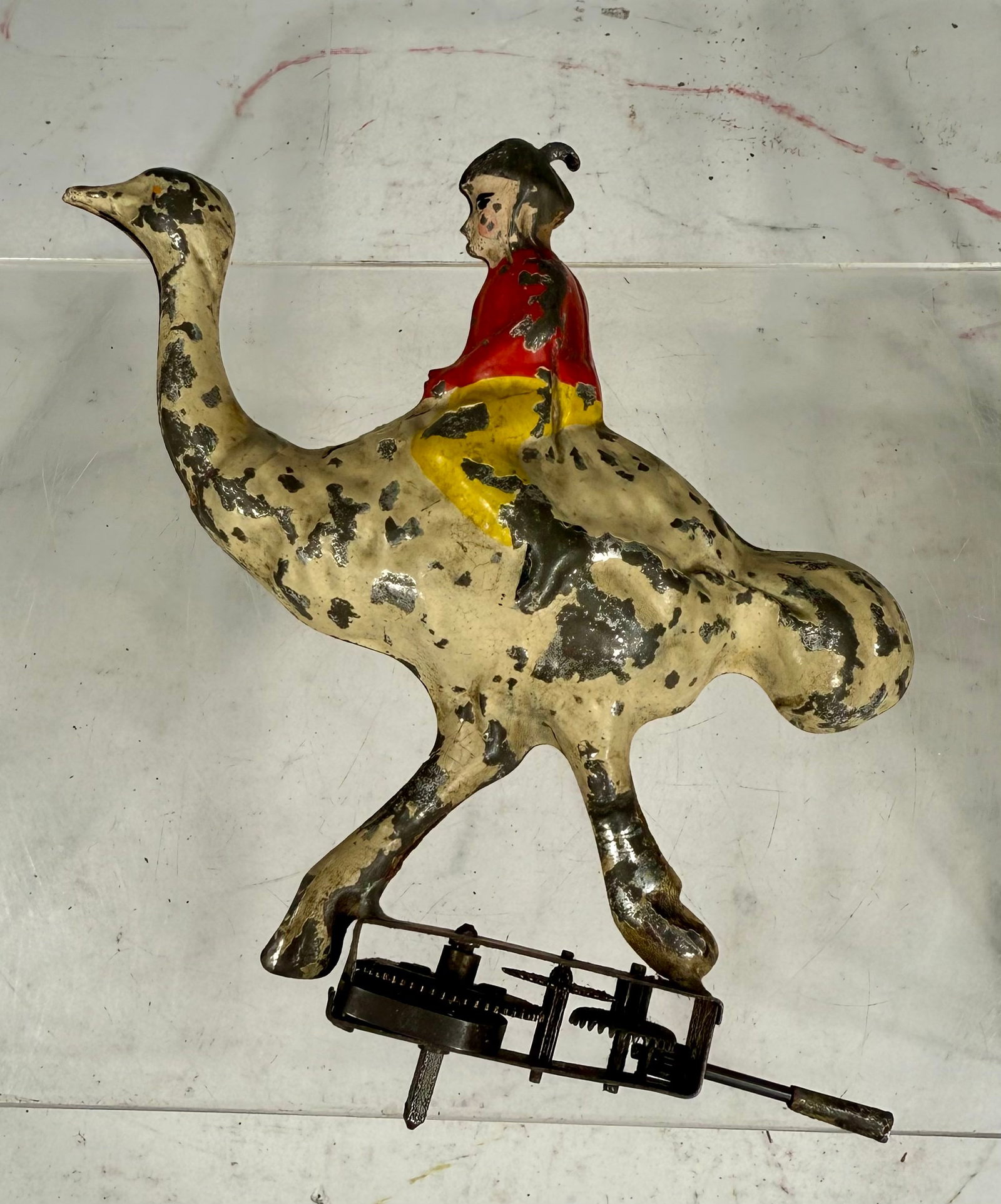 Young Boy Riding an Ostrich Wind Up Toy: German 1910s - 5 ½” T x 5 ½” W x 1 ¼” D