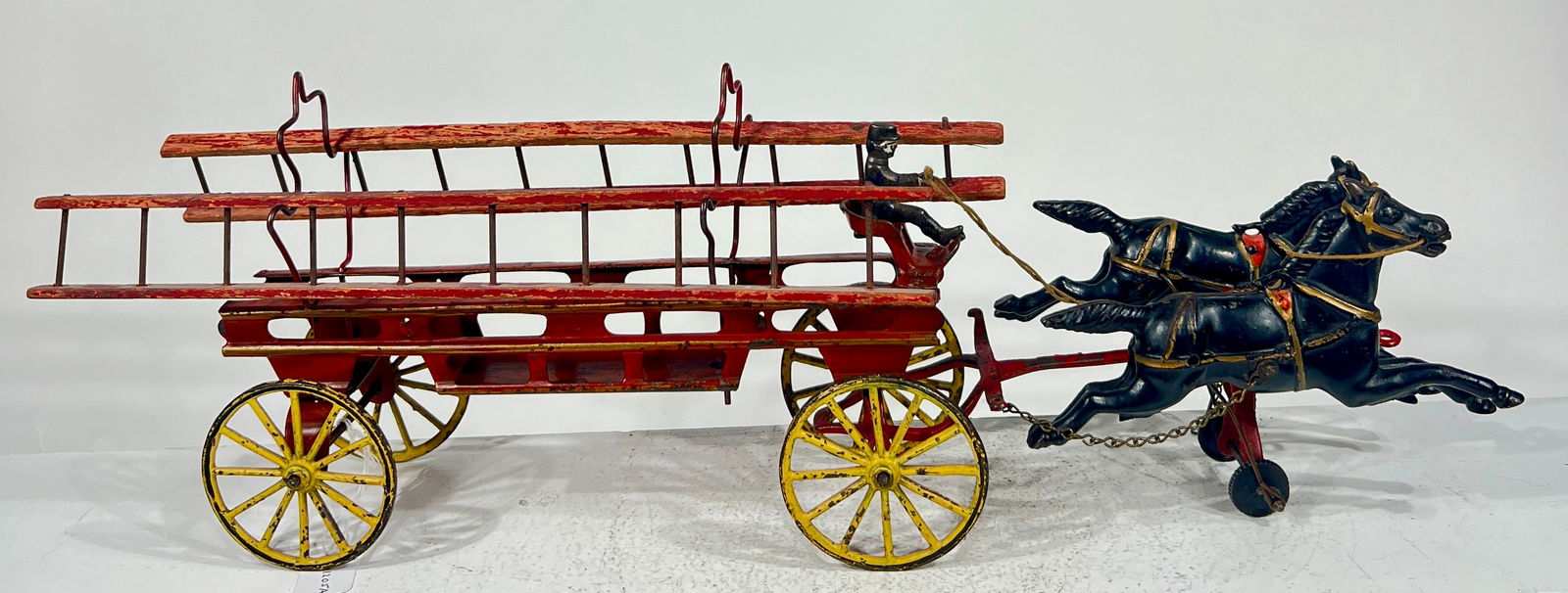 Two Horse Hook and Ladder. Tin and cast Iron: Wilkins Hardware Company Keene, NH- 190518"L x 5 3/4"T x 4 1/2" D The Olshefski Collection