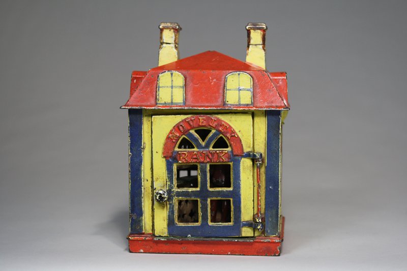 Novelty Bank – Yellow Mechanical Bank: Made by the J. & E. Stevens Company Cromwell, Connecticut – Circa 1873 Open the door and place a coin on the tray. A tap to the open door will cause it to snap shut quickly and deposit the coin into
