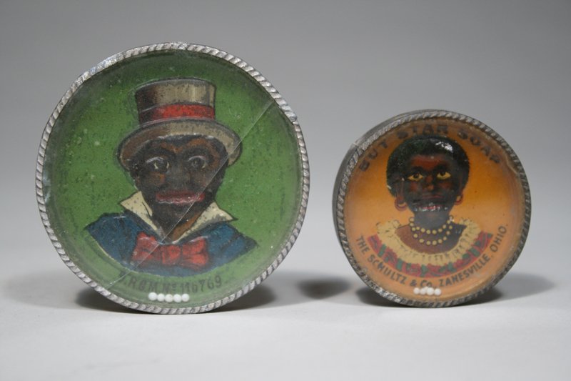 Lot: Two Dexterity Puzzles: Germany – Circa 1910 Minstrel and Black Woman that reads “Boy Star Soap”. Material: Tin and Glass