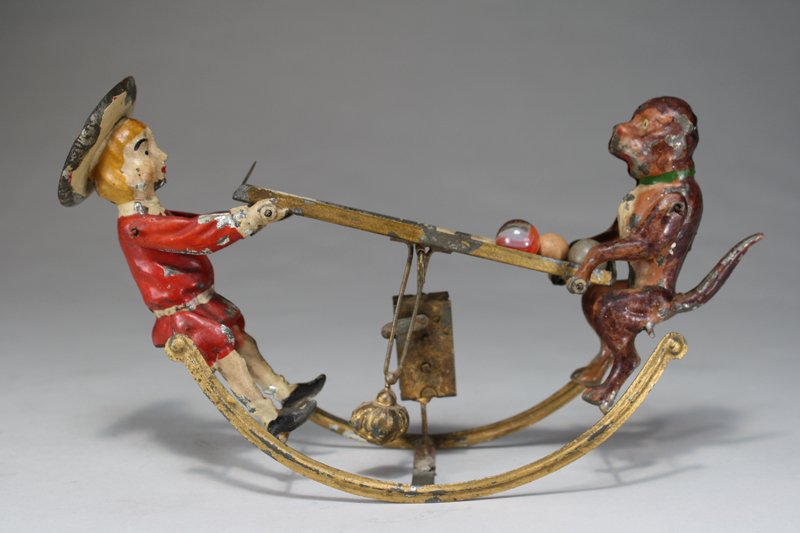 Buster Brown and Tige Marble Roll: Gunthermann • Germany – Circa 1905 An unusual teeter-totter toy that uses marbles to facilitate the action. The toy is 9 ½” long and works well. Material: Tin
