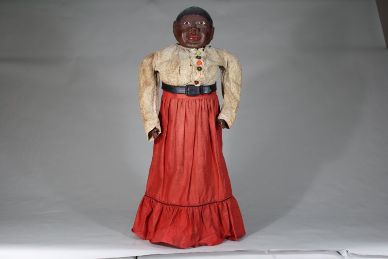 Folk Art Bottle Doll: American – Circa 1890 The head made of thick papiermache and plaster and situated atop a bottle covered by fabric. She is 30” tall. Material: Papiermache, Fabric and Glass