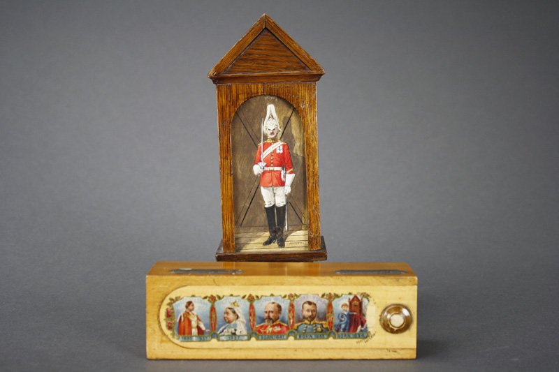 Lot: Sentry at Post / Royalty Bank Still Bank: English - Circa 1890’s The Sentry at Post is marked R. Simkin, stands 7 ?” tall. The Royalty Bank depicts William IV King 1830 - 1837, Queen Victoria, her sons and her grandson Edward of York. Thi