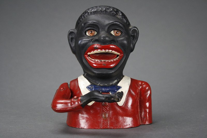 Jolly “N” English Mechanical Bank: Made by John Harper & Co. Ltd. Willenhall, England - Circa 1895 Place a coin in his hand and press the lever on his back. Your coin is swallowed. Material: Cast Iron