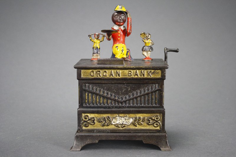 Organ Bank, Boy and Girl Mechanical Bank: Manufactured by Kyser & Rex Company Philadelphia, Pennsylvania - Circa 1882 The monkey doffs his hat in thanks for the penny you have given him. The children rotate and the bells chime when the crank 