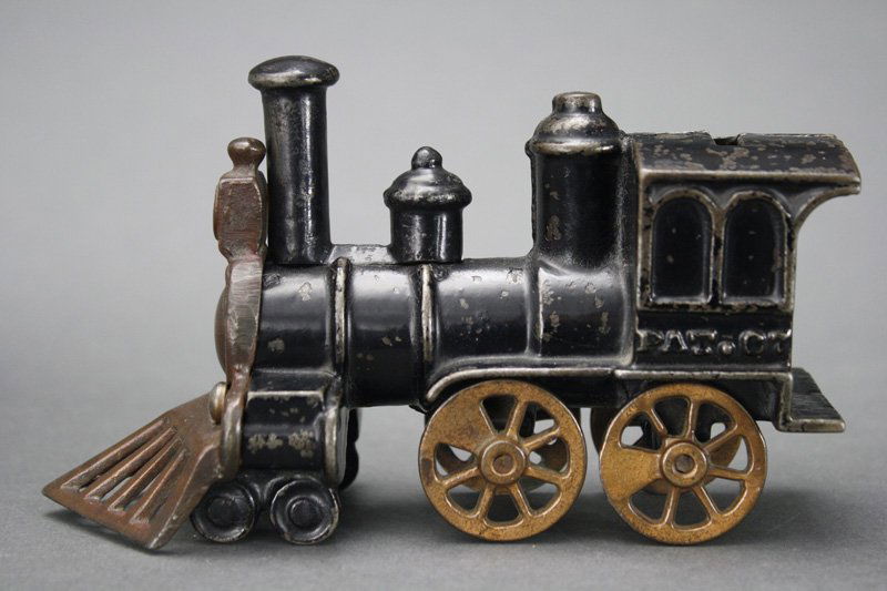 Safety Locomotive - Ebony and Copper Plate Variant: Designed by Edward T. Calby Chicago, Illinois - Circa 1881 Manufacturer Unknown This is a rare and possibly unique version of the bank with a cow catcher that screws into the piston cams, rather than