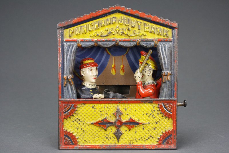 Punch and Judy, Large Letters Mechanical Bank: Shepard Hardware Company Buffalo, New York Circa 1884 Pull out the top lever to lock the figures in place. Put a coin on Judy’s dust tray and press the lower lever. Punch will rush forward to admoni