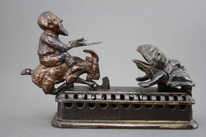 Goat, Frog and Old Man Mechanical Bank: Made by Mechanical Novelty Works New Britain, Connecticut - Circa 1885 Also known as the Initiating Bank -2nd Degree. It functions by placing a coin in the man's tray and then either pressing the butt