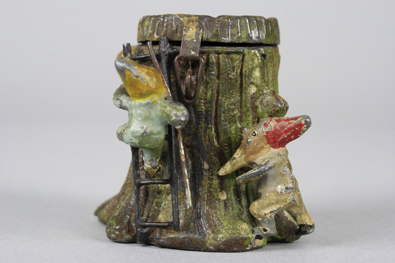 Elves at Tree Stump with Ladder Spelter Still Bank: Germany - Circa 1925 Scarce version of the bank includes two elves at work. 2.625” tall. Material: Spelter and Tin