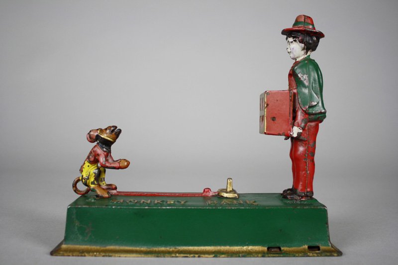 Monkey Bank - Scarce Paint Variation Mechanical Bank: Made by Hubley Manufacturing Company Lancaster, Pennsylvania - Circa 1930 The monkey springs forward to deposit the coin into the organ grinder’s hurdy-gurdy. This is a scarce painted variation with
