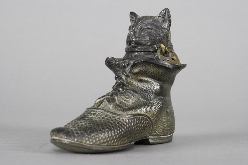 Cat in Boot: German - Circa 1925 This delightful bank is 4.375” long. Material: Silvered Lead
