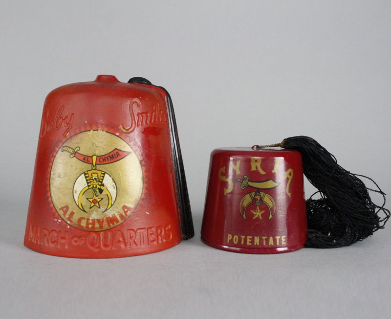 Syria Fez and Baby Smiles Fez: American - Circa 1920 Syria Fez is 3.25” tall and Baby Smiles Fez is 5.5” tall. We have not seen the Baby Smiles Fez before. Material: Aluminum, Tin and Steel