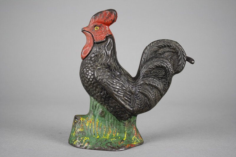 Rooster Bank: Made by the Kyser & Rex Company Philadelphia, Pennsylvania - Circa 1880 The rooster moves his head when lever is depressed and coin is deposited. Material: Cast Iron