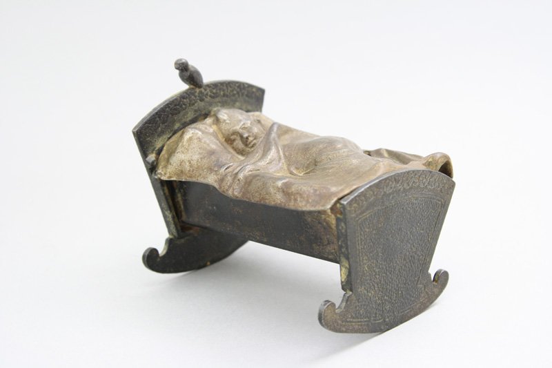 Baby in a Cradle Still Bank: America - Circa 1895 Material: Cast Iron and Tin