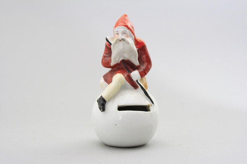 Santa on Snowball Still Bank: German - Circa 1915 - 3.75” Tall A scarce and colorful bank with a great theme and is pristine! Material: Porcelain