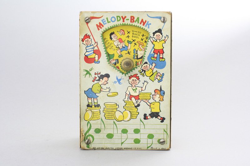Melody Bank Mechanical Bank: Electric Coding Machine Co. - New York - Dated 1946 Place a coin in one of three coin slots on top of the bank. Wind the lever and the coin drops in and music plays. Material: Tin and Paper