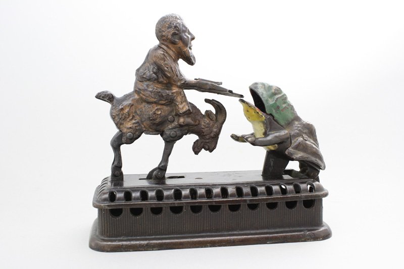 Initiating Bank - 2nd Degree Mechanical Bank: Made by Mechanical Novelty Works - New Britain, Connecticut - Circa 1885 Also known as the “Goat, Frog and Old Man”. It functions by placing a coin in the man’s tray and then either pressing the