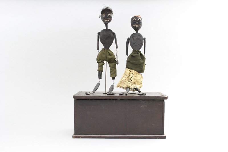Folk Art Jigging Toy: American - Circa 1880’s - 15” Tall This is a folk art or cottage industry produced toy. It has a clock mechanism and a music box mechanism. It works okay. Material: Papier mache and Wood