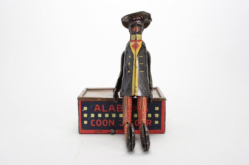 Alabama Coon Jigger: Ferdinand Strauss Co. American - Circa 1930 - 9” Tall The toy works well. Material: Tin
