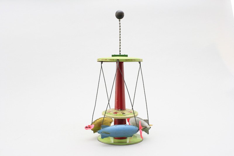 Zeppelin Go Round: Buffalo Toys American - Circa 1930 - 14” Tall We have not previously seen this kinetic toy. Press the pump down and release it, the zeppelins spin around. Material: Tin with Celluloid Propellers