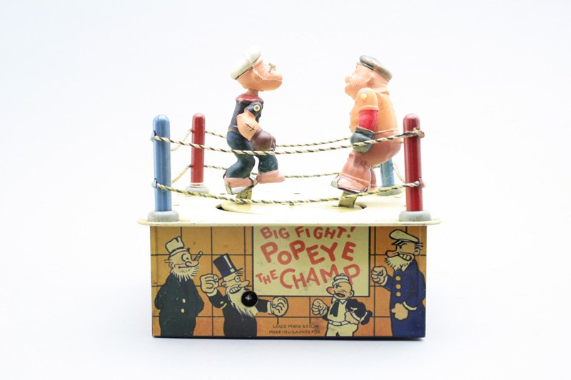 Popeye the Champ Louis Marx Co.: New York - Circa 1938 A wonderfully graphic Louis Marx toy that works very well. Material: Tin and Celluloid