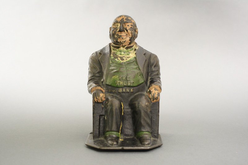 The Trust Bank: J. & E. Stevens Co. - Circa 1890 It depicts a rotund banker sitting in a chair. The implication being he has gotten fat on his profits. Would you trust this guy? Material: Cast Iron