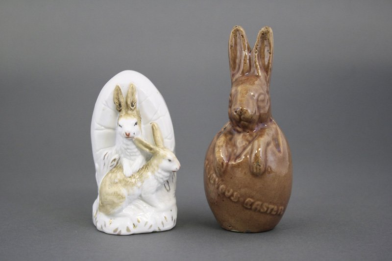 Two Rabbit Themed Banks: European - Circa 1910 - 3.75 / 4.75” H One of two rabbits in front of an egg and the other popping out of an egg. These were little Easter presents. Material: Glazed Bisque