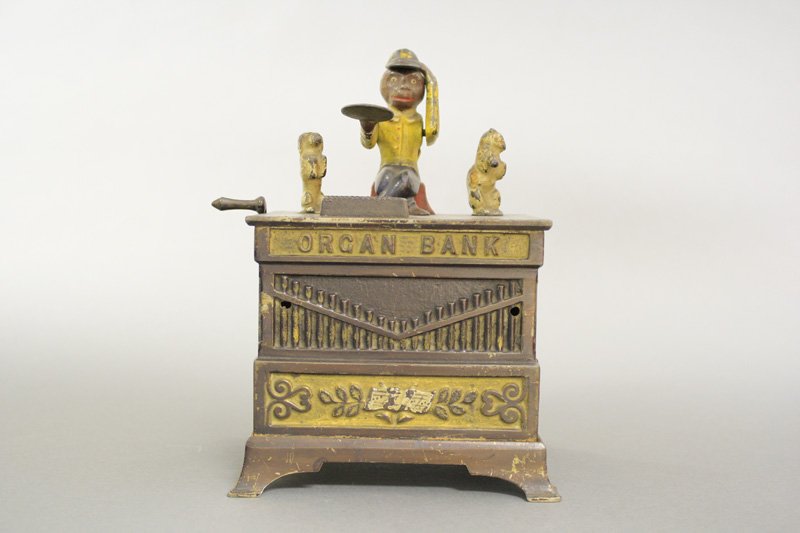 Organ Bank, Cat and Dog: Kyser & Rex Company Philadelphia, Pennsylvania - Circa 1882 The monkey doffs his hat in thanks for the penny you have given him. The animals rotate and the bells chime when the crank is turned. Materi