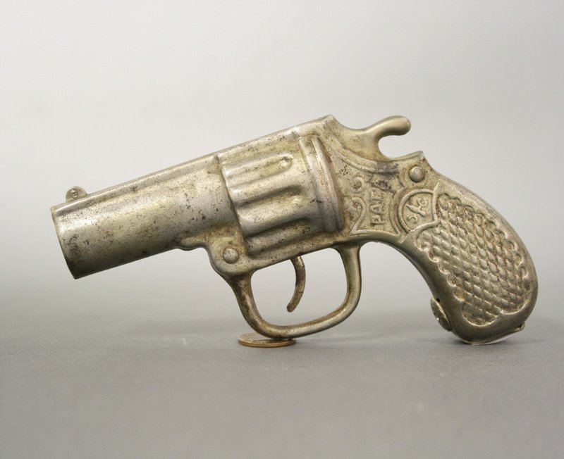 Pistol Bank, Tin: Richard Elliot Co. Chicago, Illinois - Circa 1909 Place a dime in the end of the barrel. Pull the trigger and the coin is deposited. Material: Sheet Steel
